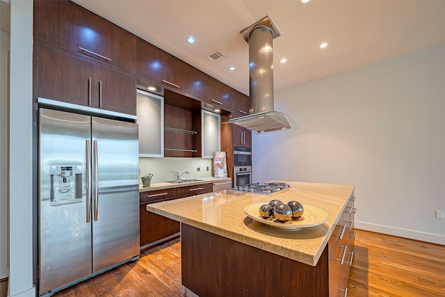 kitchen featuring light wood-style flooring, island range hood, stainless steel appliances, a sink, and modern cabinets