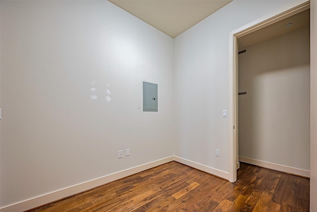 unfurnished room featuring dark wood finished floors, electric panel, and baseboards