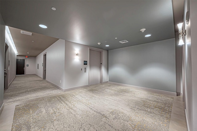 spare room with elevator, baseboards, visible vents, and recessed lighting