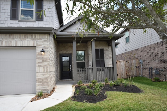 doorway to property with a garage, a porch, a lawn, and brick siding