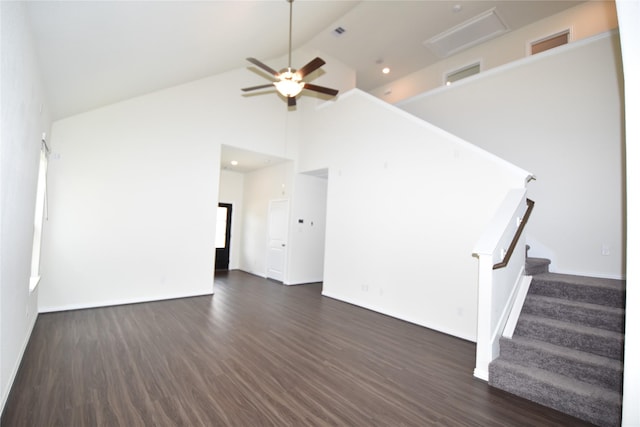 unfurnished living room featuring visible vents, dark wood finished floors, a ceiling fan, stairs, and high vaulted ceiling