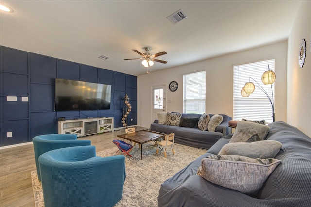 5723 Morning Vista Rd, Katy, TX 77493 - living area with a ceiling fan, visible vents, a decorative wall, and light wood-style flooring
