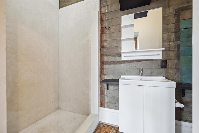 bathroom with a sink and wood walls