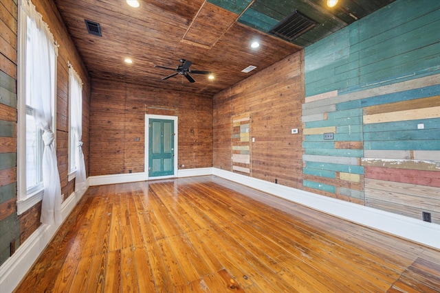 unfurnished room featuring a ceiling fan, wooden ceiling, hardwood / wood-style floors, wood walls, and recessed lighting