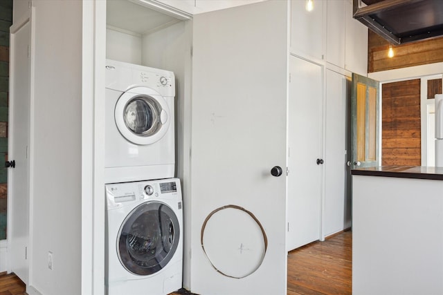 washroom with laundry area, wood finished floors, and stacked washer and clothes dryer