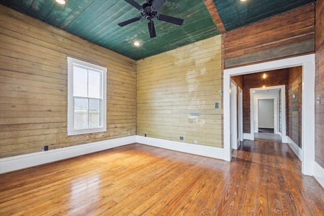 unfurnished room with wood ceiling, wood-type flooring, ceiling fan, and baseboards