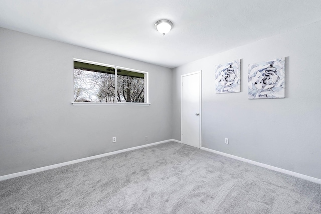 empty room featuring baseboards and carpet flooring