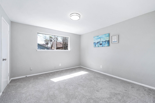 carpeted empty room featuring baseboards