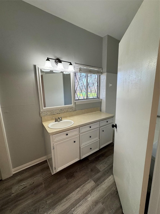 bathroom featuring wood finished floors, vanity, and baseboards