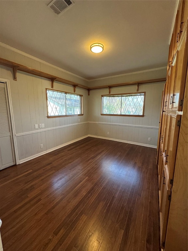 unfurnished bedroom with ornamental molding, visible vents, and dark wood finished floors