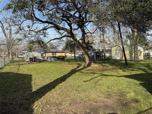 view of yard featuring an outbuilding, fence, and a storage unit