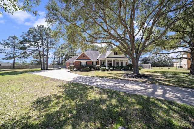 view of front of property featuring brick siding, a front yard, and fence