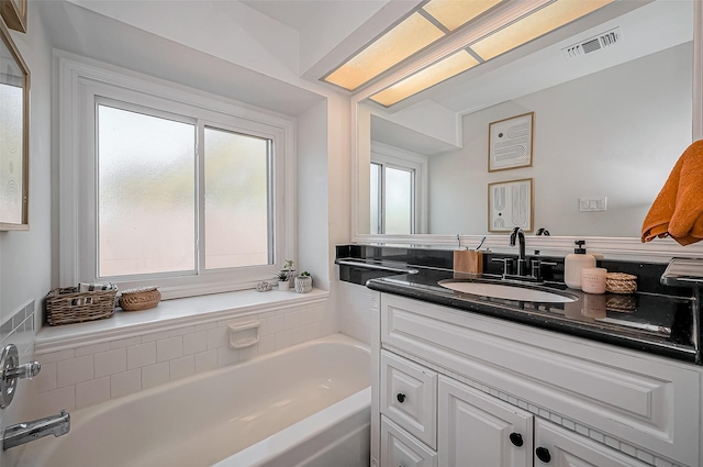 full bath featuring a bath, vanity, and visible vents