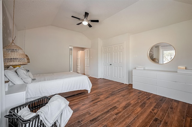 bedroom featuring lofted ceiling, a textured ceiling, wood finished floors, a ceiling fan, and a closet