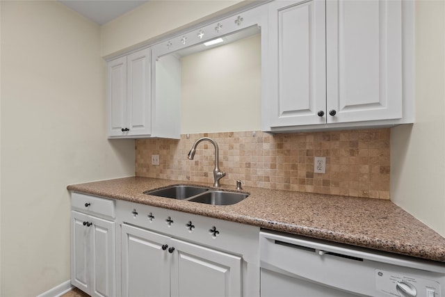 kitchen featuring light stone counters, a sink, white cabinets, backsplash, and dishwasher