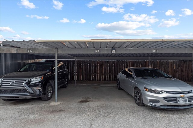 covered parking lot featuring fence