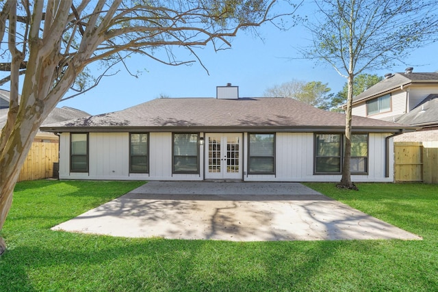 back of house with fence, a lawn, french doors, a chimney, and a patio area