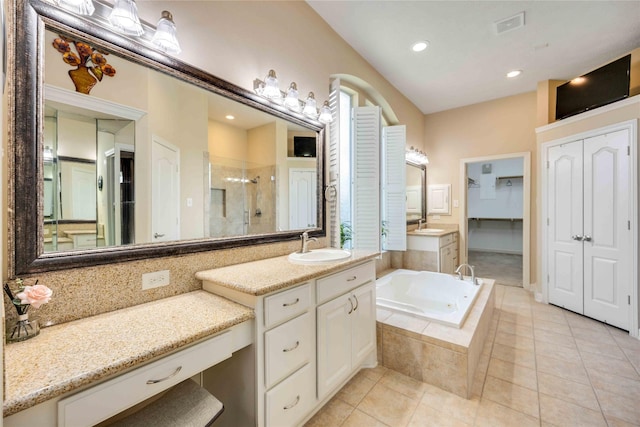 bathroom with a stall shower, a sink, tile patterned flooring, a closet, and a bath