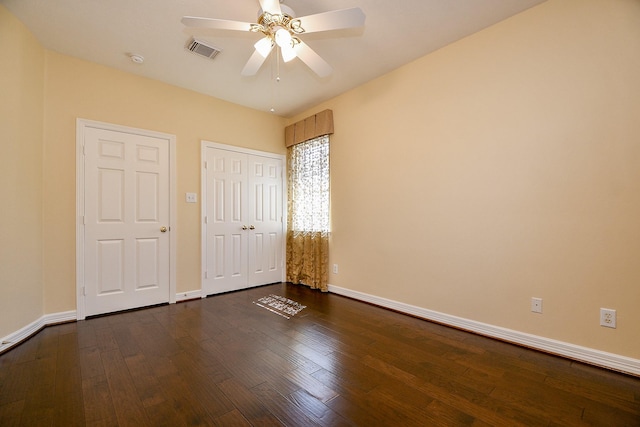 unfurnished bedroom with visible vents, ceiling fan, baseboards, a closet, and dark wood-style floors