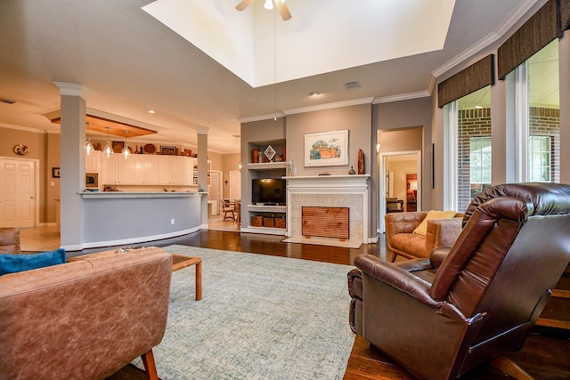 living area with a fireplace with flush hearth, dark wood-style floors, and ornamental molding