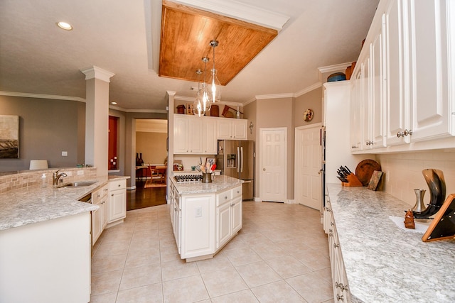 kitchen with light tile patterned floors, decorative backsplash, appliances with stainless steel finishes, and a sink