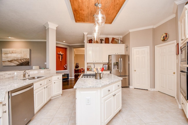 kitchen featuring light tile patterned floors, a kitchen island, appliances with stainless steel finishes, and a sink