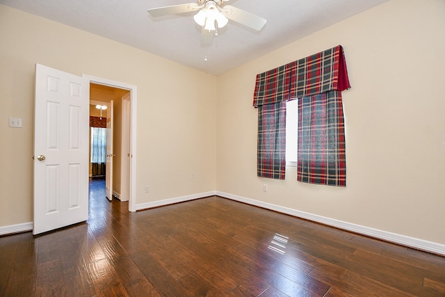 empty room featuring baseboards, wood-type flooring, and ceiling fan