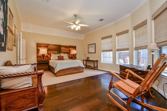 bedroom featuring crown molding, wood finished floors, baseboards, and visible vents