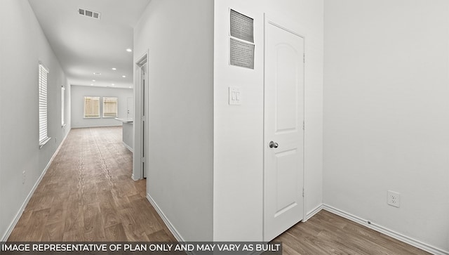 corridor featuring baseboards, visible vents, wood finished floors, and recessed lighting