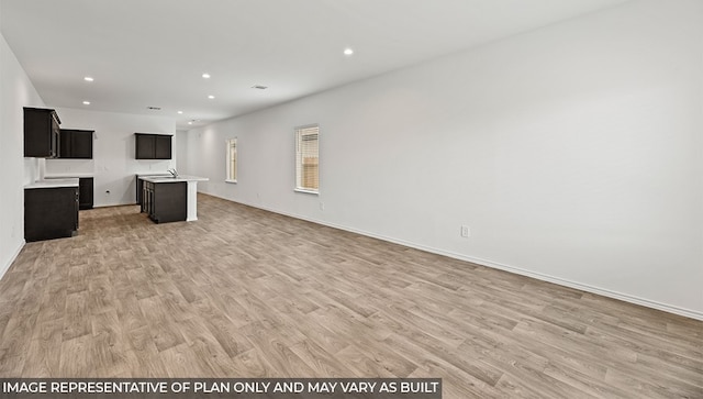 kitchen featuring open floor plan, light countertops, light wood-type flooring, and recessed lighting