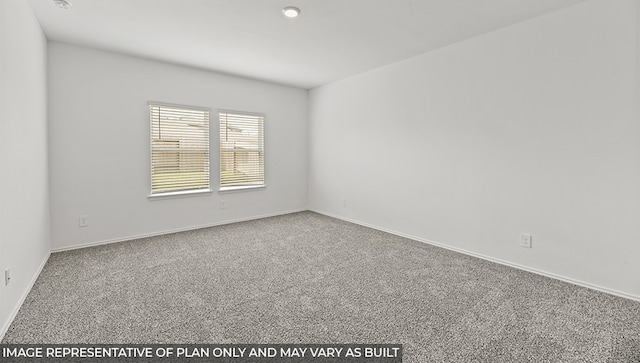 carpeted spare room featuring baseboards