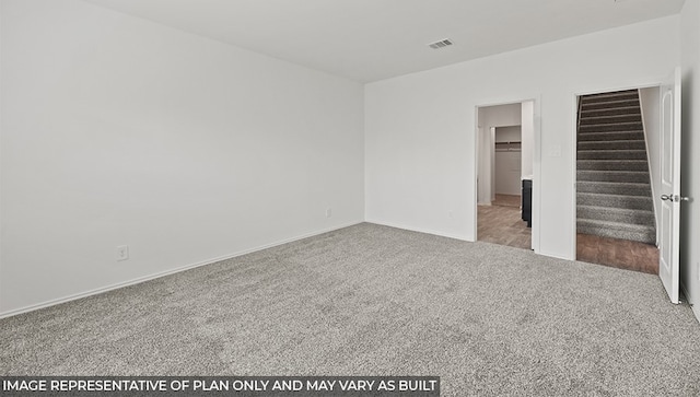 unfurnished bedroom with a spacious closet, carpet, and visible vents