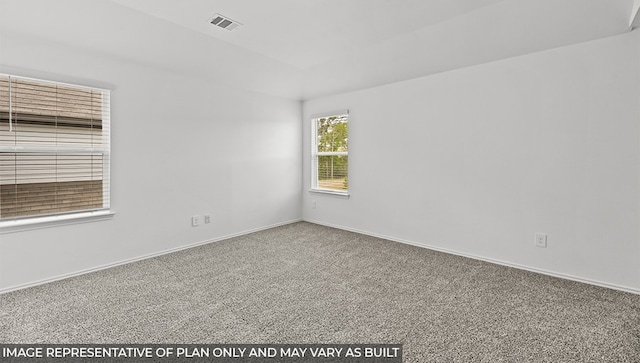 empty room with carpet flooring, visible vents, and baseboards