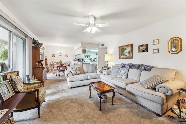 carpeted living area with visible vents and ceiling fan with notable chandelier