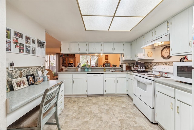 kitchen featuring white appliances, under cabinet range hood, and white cabinetry