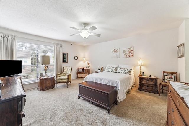 bedroom featuring light carpet, a textured ceiling, a ceiling fan, and baseboards