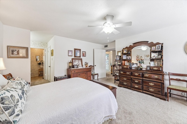 bedroom featuring ceiling fan, ensuite bath, carpet flooring, and visible vents