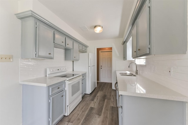 kitchen with white appliances, a sink, and gray cabinetry