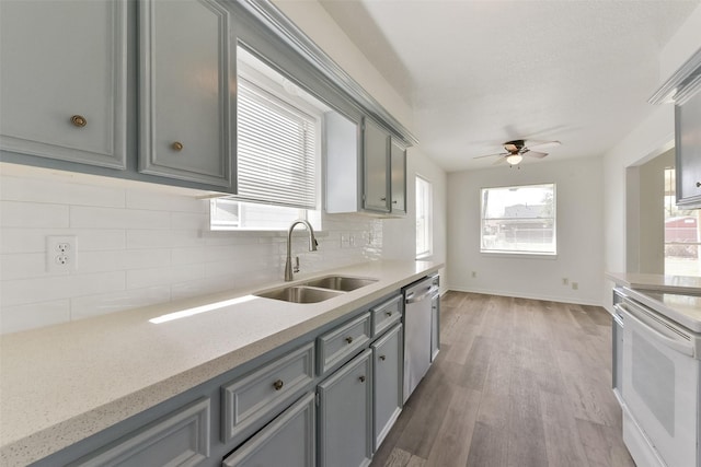 kitchen featuring a sink, stainless steel dishwasher, gray cabinets, light wood finished floors, and white electric range oven