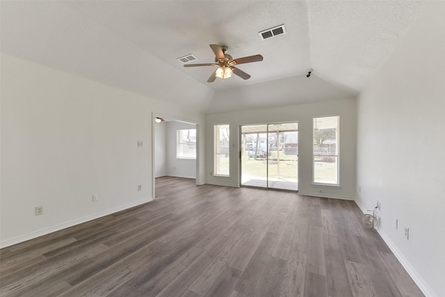 unfurnished living room featuring dark wood-style floors, visible vents, vaulted ceiling, ceiling fan, and baseboards