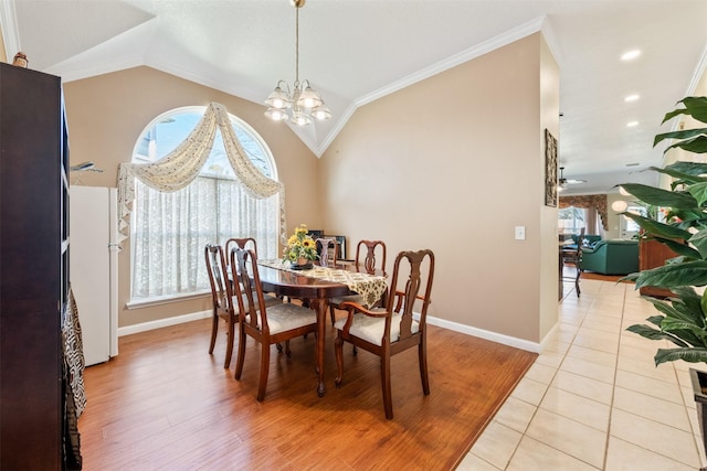 dining area with lofted ceiling, baseboards, a chandelier, and light tile patterned flooring