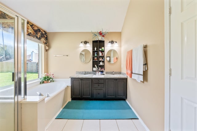 full bath with tile patterned floors, double vanity, a sink, and a bath