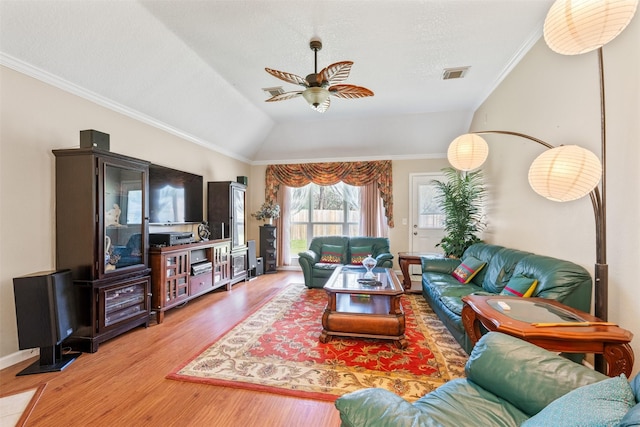 living room with ceiling fan, wood finished floors, visible vents, vaulted ceiling, and ornamental molding