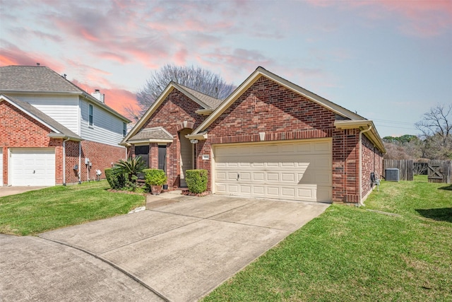 view of front of home featuring brick siding, a yard, an attached garage, and fence