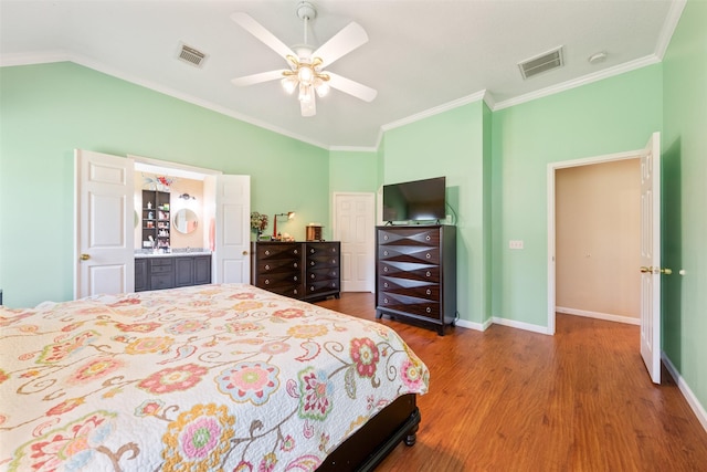 bedroom with visible vents, vaulted ceiling, baseboards, and wood finished floors