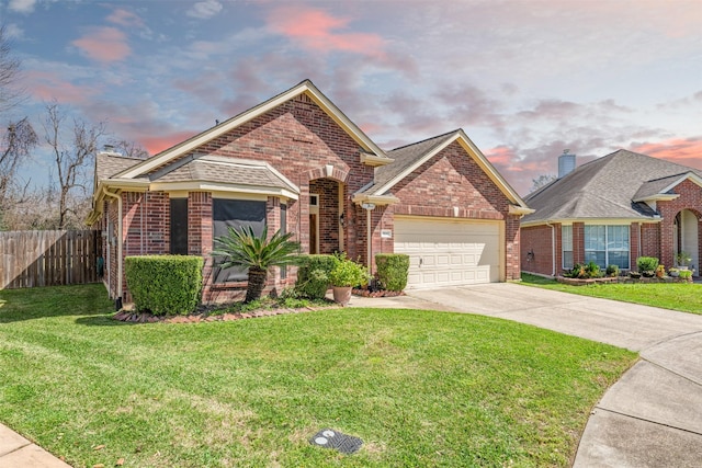 view of front of home with an attached garage, brick siding, fence, driveway, and a front yard