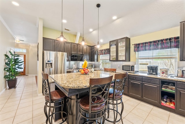 kitchen featuring light tile patterned floors, appliances with stainless steel finishes, and a breakfast bar area