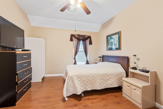 bedroom with vaulted ceiling, light wood finished floors, a ceiling fan, and baseboards