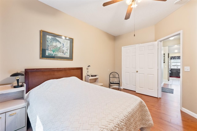 bedroom with light wood-style floors, ceiling fan, and baseboards