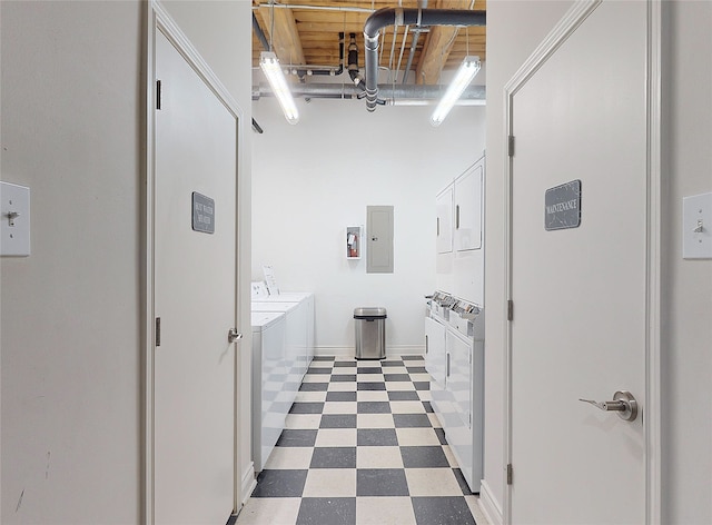 bathroom featuring baseboards, washer and clothes dryer, electric panel, and tile patterned floors